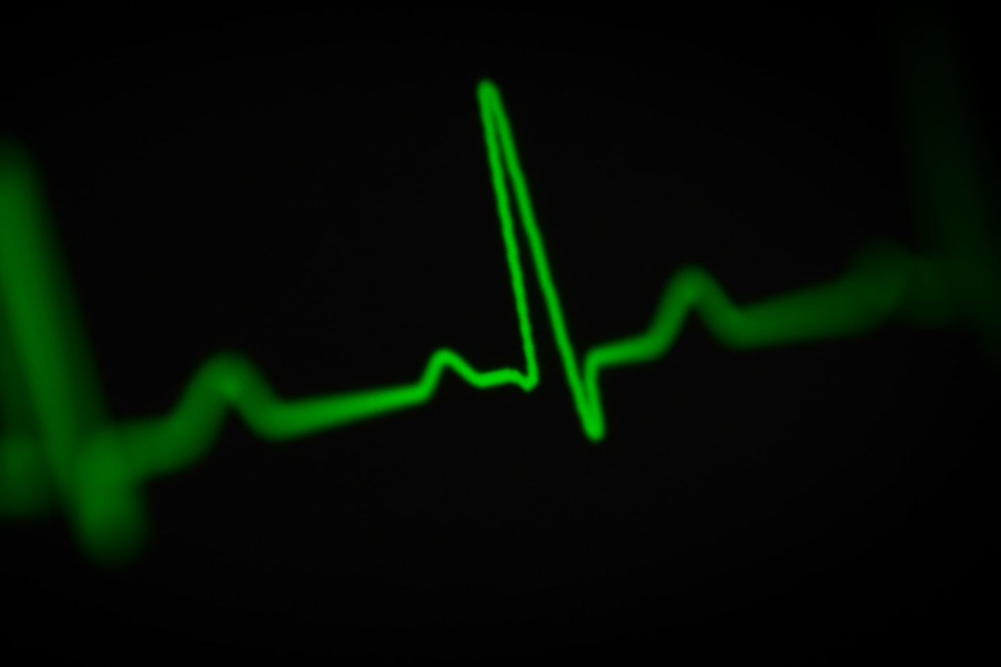 a green heart beat on a black background