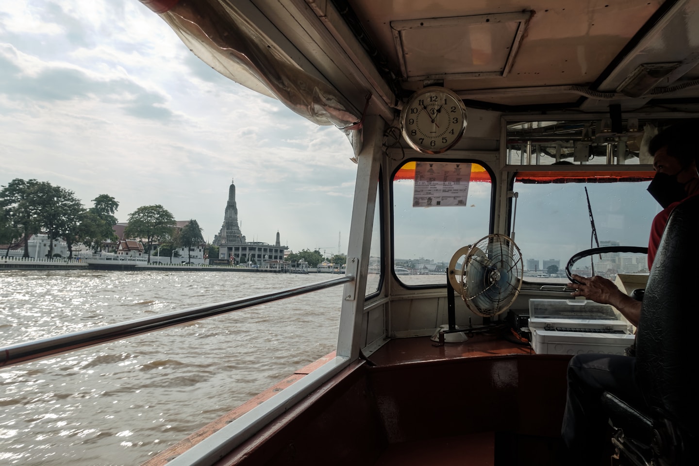 View from a boat of a temple on the river.